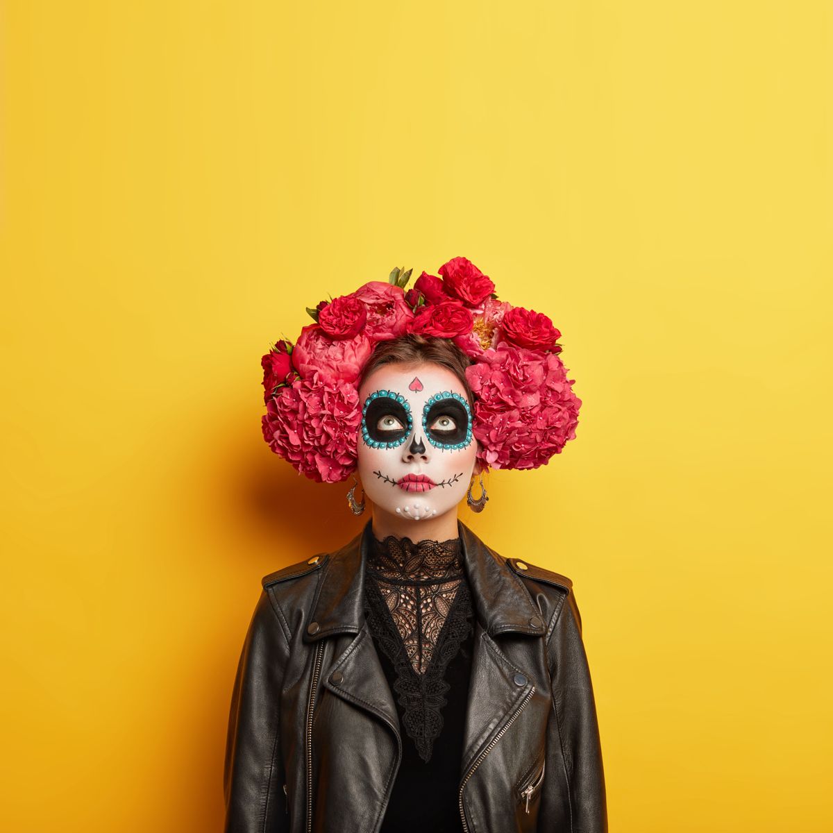 Día de los Muertos makeup with red flower crown on yellow
