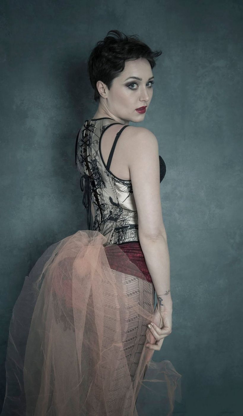 Model in a structured corset and tulle skirt in moody studio light